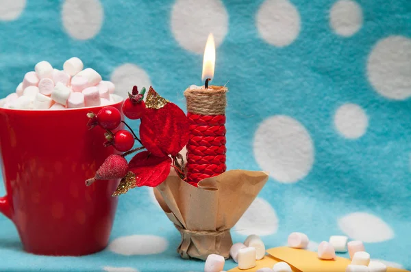 Guimauve dans une tasse rouge près des accessoires de Noël sur un fond bleu — Photo