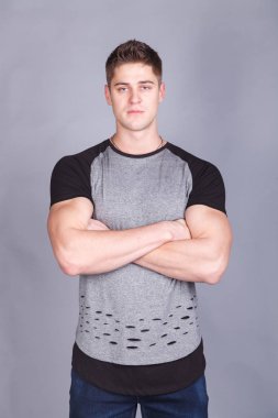 T-shirt gri bir arka plan üzerine genç atletik erkek