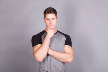 T-shirt gri bir arka plan üzerine genç atletik erkek