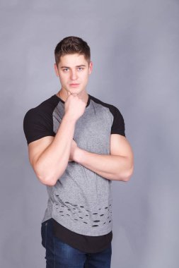 T-shirt gri bir arka plan üzerine genç atletik erkek