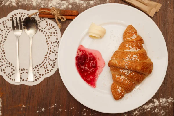 It lies on a plate with croissants, jam and butter — Stock Photo, Image