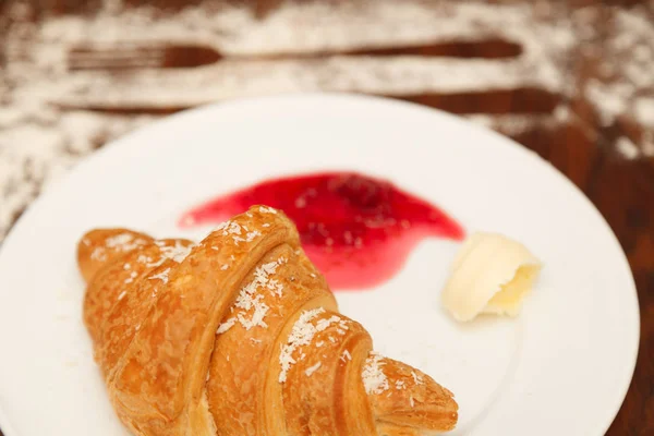 It lies on a plate with croissants, jam and butter — Stock Photo, Image