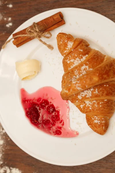 It lies on a plate with croissants, jam and butter — Stock Photo, Image