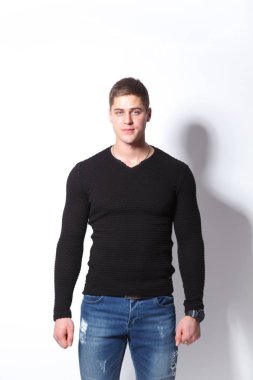 Kendinden emin ve şık. Neşeli genç adam ayakta beyaz arka planı süre kamera bakıyor