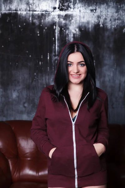 Смішна сексуальна дівчина, що стоїть на фоні дивана. Сексуальна жінка в чорній білизні і бордовий светр — стокове фото