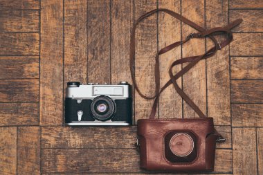 Film kamerası ve ona yalan ahşap arka plan üzerinde kapak.