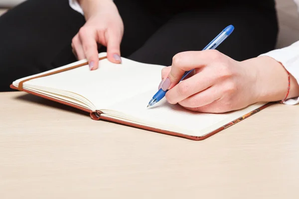Mãos femininas com caneta escrita no caderno — Fotografia de Stock