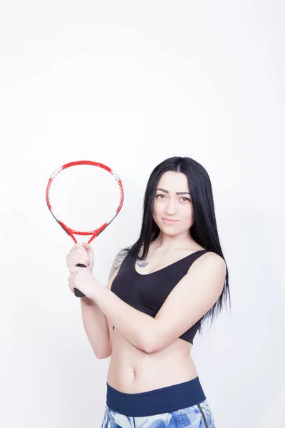 Fille sportive avec une raquette de tennis. Fille dans un haut noir sur un fond blanc — Photo