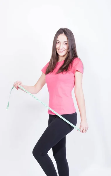 Atlética mujer delgada midiendo su cintura por cinta métrica después de una dieta sobre fondo blanco — Foto de Stock
