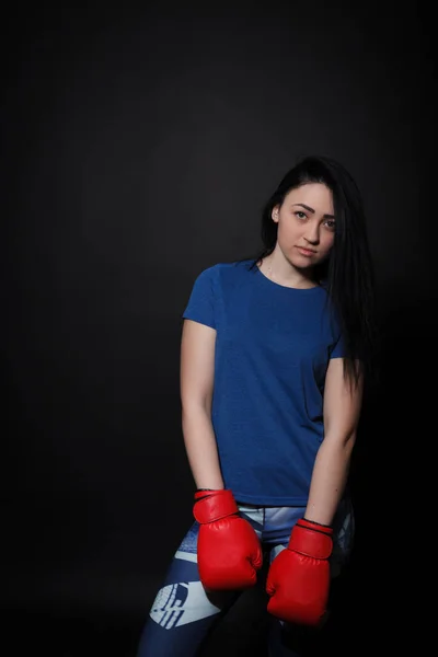 Женщина в красных боксерских перчатках. Спортивная женщина на черном фоне — стоковое фото