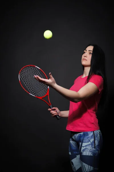 Mulher com uma raquete de tênis na mão jogando uma bola de tênis — Fotografia de Stock