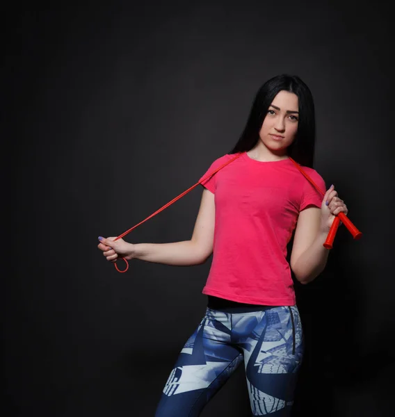 Sports a beautiful woman holding a red rope in the hands of — Stock Photo, Image