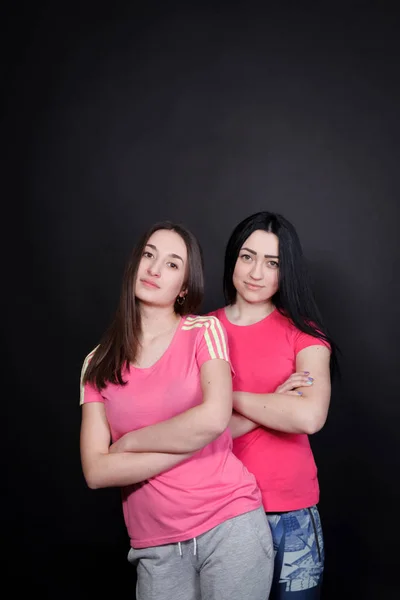 Two athletic young woman on a black background — Stock Photo, Image