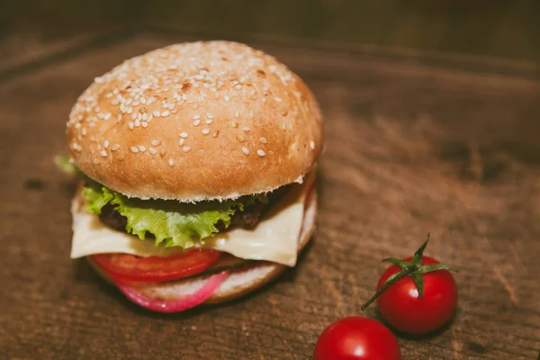 Saftiger Burger und Tomaten auf dem Brett — Stockfoto
