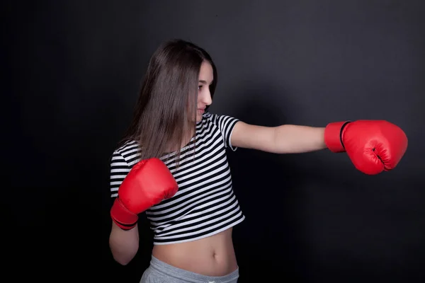 Vrouw imiteert klap met bokshandschoenen — Stockfoto