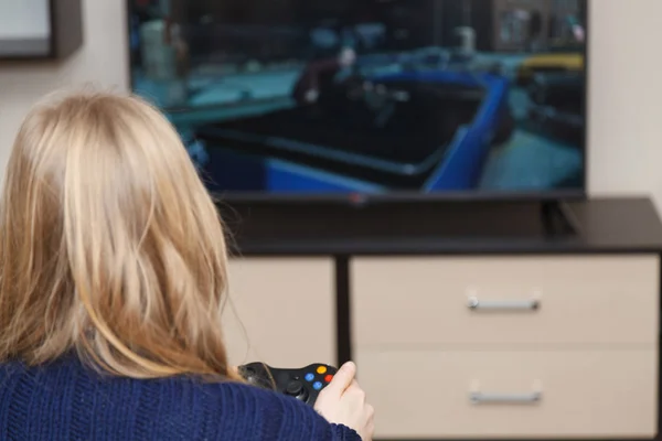 Tânără femeie care joacă jocuri video stând pe canapea — Fotografie, imagine de stoc