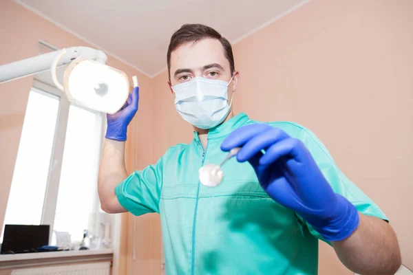 Dentista ajustar la lámpara antes de comenzar el trabajo — Foto de Stock