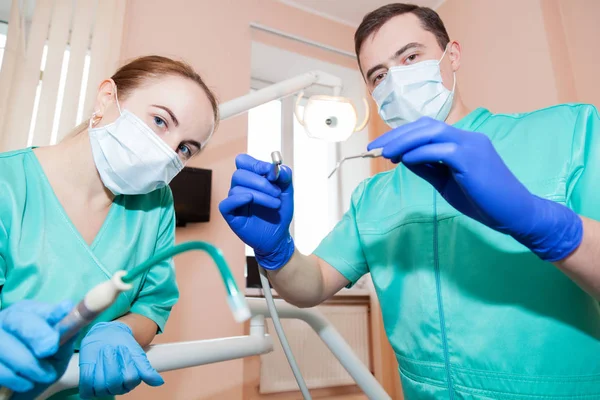 Hombre dentista, su asistente en el consultorio dental — Foto de Stock