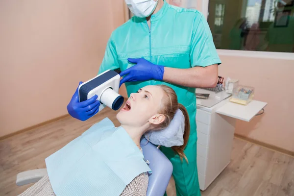Dentysta specjalne urządzenie sprawdza, czy zęby kobiety — Zdjęcie stockowe