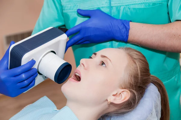 Dentista dispositivo especial examina os dentes de uma mulher — Fotografia de Stock