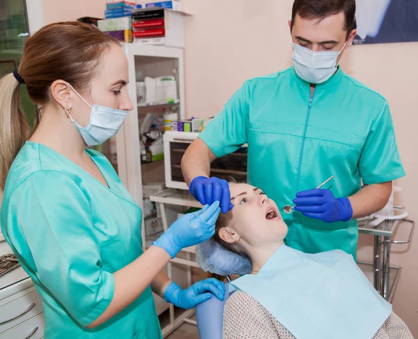 Dos dentistas están tratando a un paciente — Foto de Stock