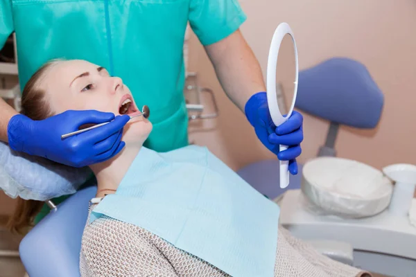 Dentista y paciente observan los resultados del tratamiento dental — Foto de Stock
