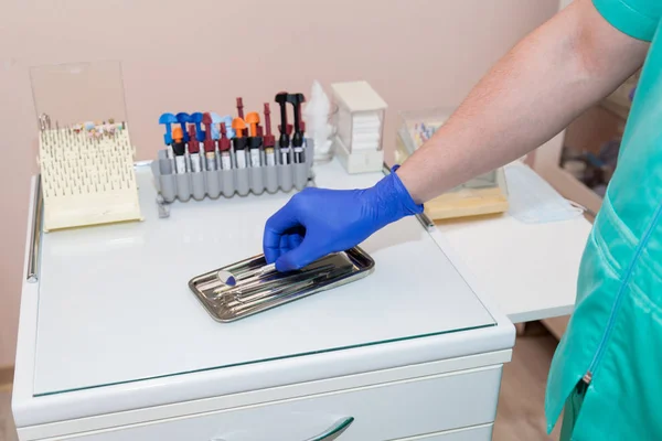 Dentista toma herramientas con una mano — Foto de Stock