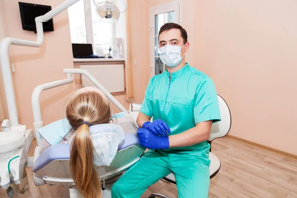 Manliga tandläkare sitter nära patienten — Stockfoto