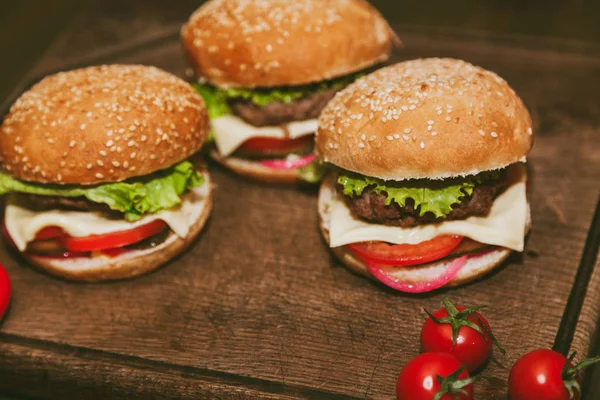 Burger auf einem Brett mit Tomaten — Stockfoto