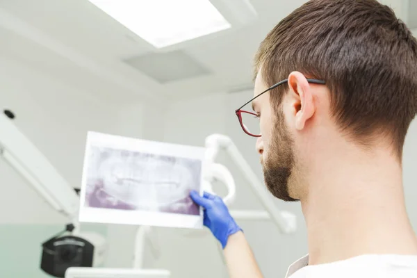 El dentista examina una instantánea de los dientes — Foto de Stock