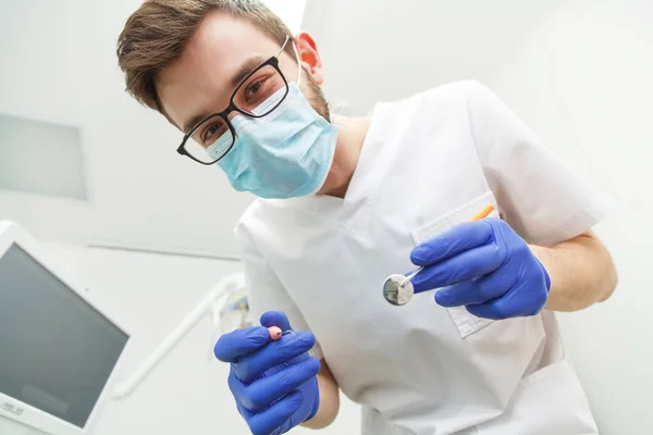 Jovem dentista masculino trabalhando — Fotografia de Stock