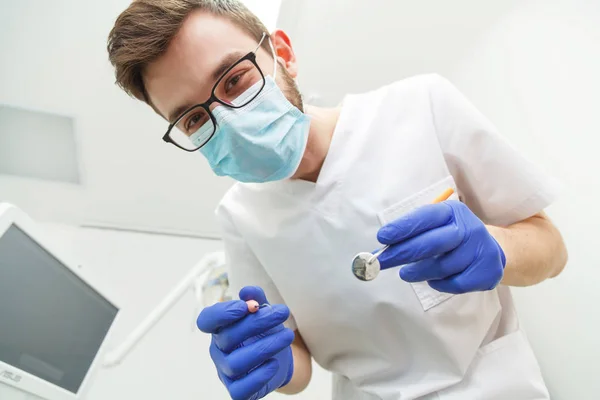 Joven dentista masculino trabajando — Foto de Stock