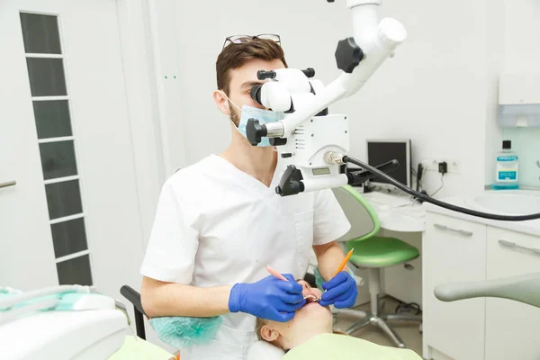 İş yerinde erkek diş hekimi hastaya yordamlar yürütmektedir — Stok fotoğraf