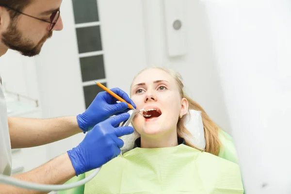 Dentista realiza o procedimento de odontologia — Fotografia de Stock