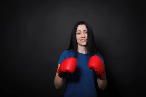 Mujer joven deportiva haciendo patada en guantes de boxeo —  Fotos de Stock