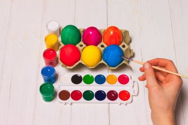 Mutlu Paskalyalar! Bir anne, baba ve yumurta boyama kızları. Mutlu aile Paskalya için hazırlanıyor.