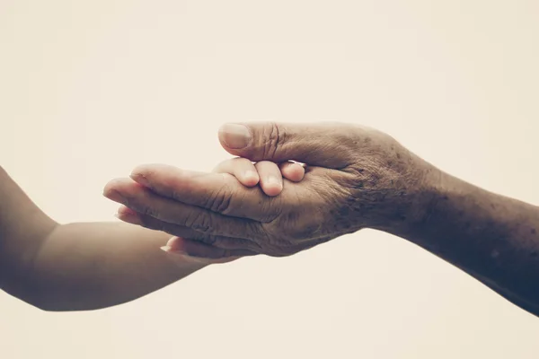 Antigua mano femenina sosteniendo la mano del bebé joven — Foto de Stock