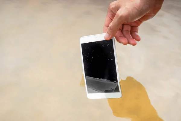 Рука держит мокрый смартфон — стоковое фото