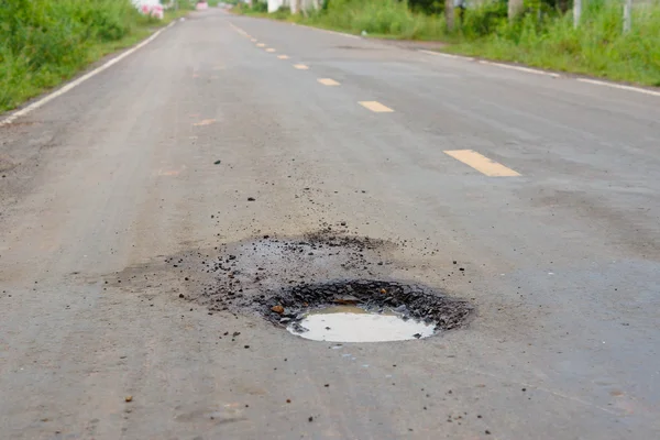 Beschadigde weg met gaten — Stockfoto