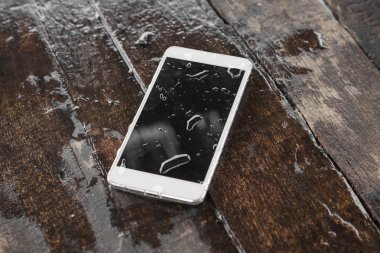 ahşap arka plan üzerinde ıslak smartphone