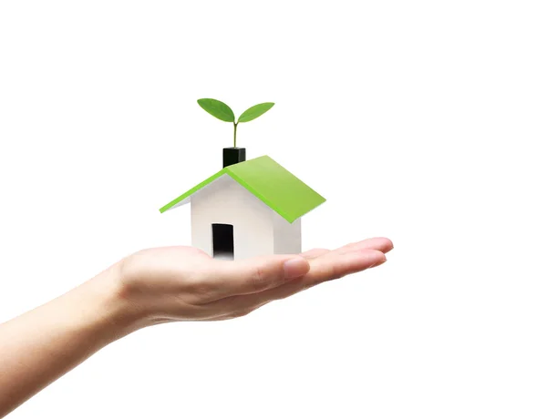 Mão segurando uma pequena casa verde — Fotografia de Stock