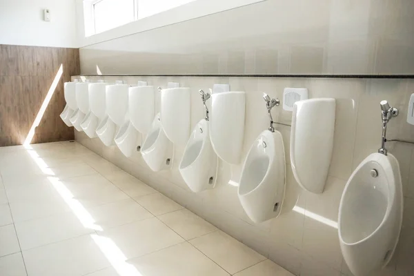 Urinals on wall under window — Stock Photo, Image