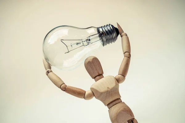 Mannequin carrying light bulb — Stock Photo, Image