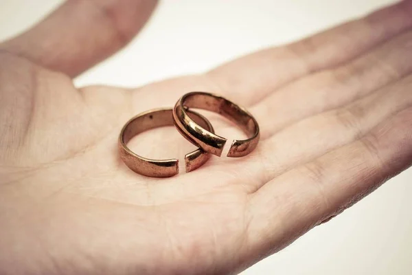 Hand holding broken rings — Stock Photo, Image