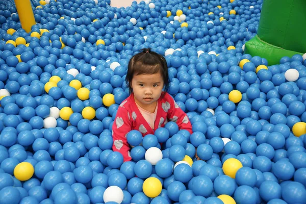 Kid playing in the ball pit — Stock Photo, Image