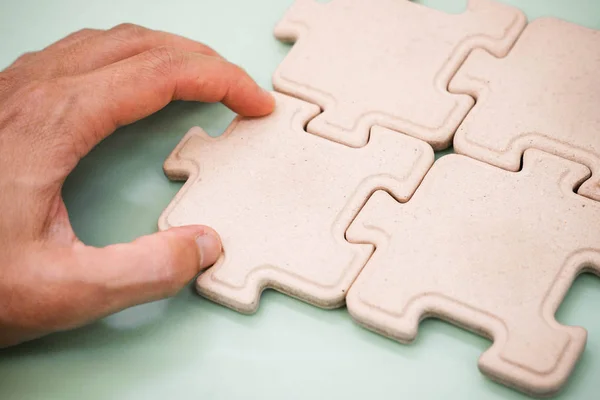 Hand of a businessman putting pieces of jigsaws — Stock Photo, Image