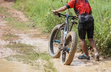 Dağ bisiklet bisikletçi bir çamurlu yolda sürme