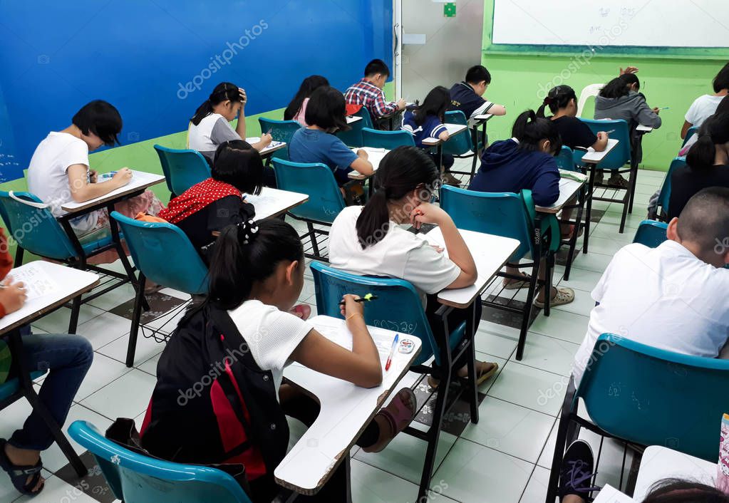  Asian students studying in a small class of a tutorial school