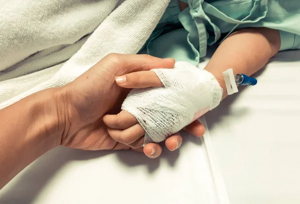 Far innehav sjuk baby's hand — Stockfoto