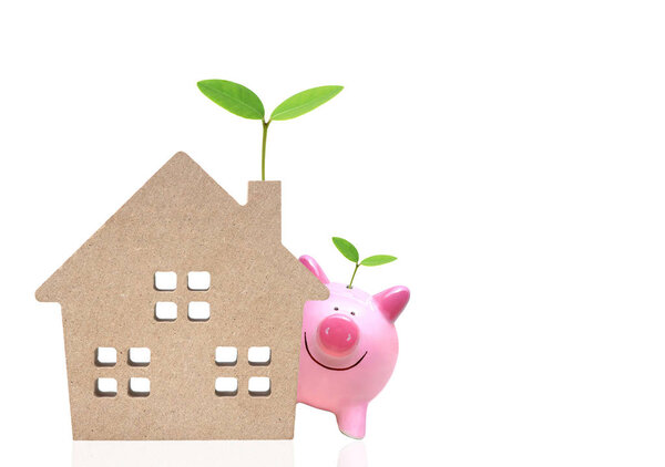 A pink piggy bank and a wooden house with green trees